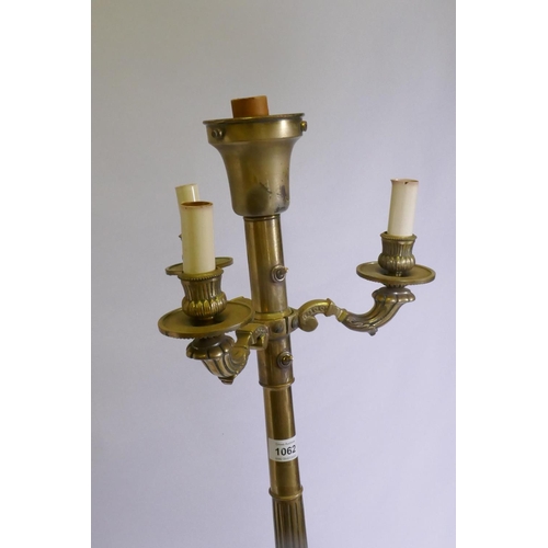 1062 - A brass floor lamp with three branches and fluted column, raised on three paw supports, 142cm high