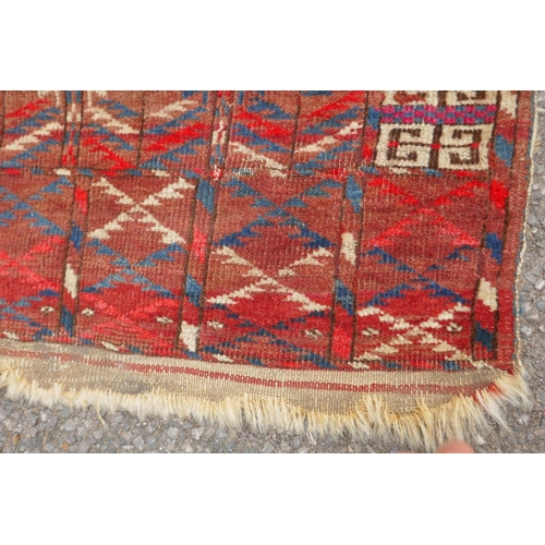 1065 - A rust ground Turkmen Bokhara rug, 115 x 140cm