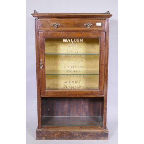 1067 - A C19th rosewood cabinet with single drawer and glass door, later sign-written in gilt with chemist'... 