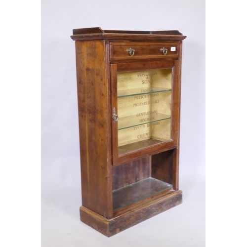 1067 - A C19th rosewood cabinet with single drawer and glass door, later sign-written in gilt with chemist'... 