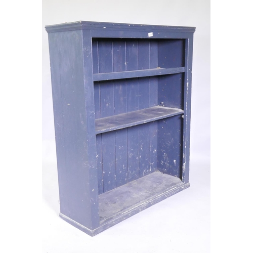 1078 - A painted open book-case with two shelves, raised on a plinth base, 102 x 34 x 123 cm