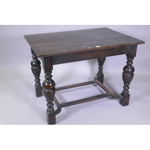 1081 - An oak centre table with plank top, raised on turned bulbous supports united by a shaped stretcher, ... 