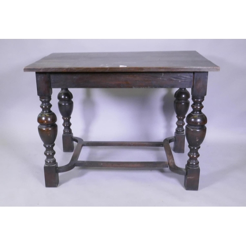 1081 - An oak centre table with plank top, raised on turned bulbous supports united by a shaped stretcher, ... 