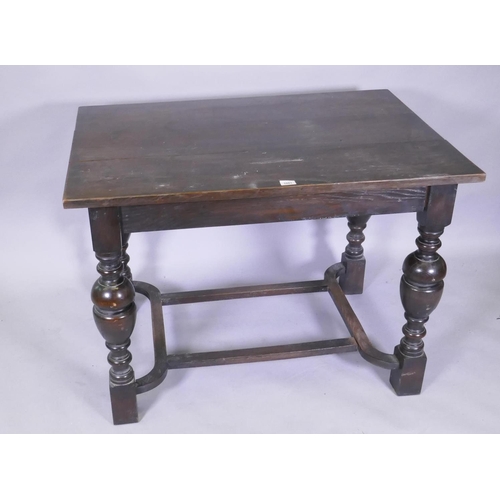 1081 - An oak centre table with plank top, raised on turned bulbous supports united by a shaped stretcher, ... 