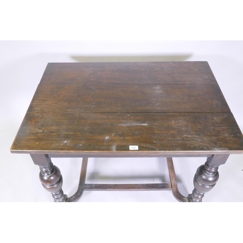 1081 - An oak centre table with plank top, raised on turned bulbous supports united by a shaped stretcher, ... 