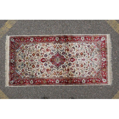 1086 - A Persian cream ground silk Tabriz rug with red borders, 62 x 122cm