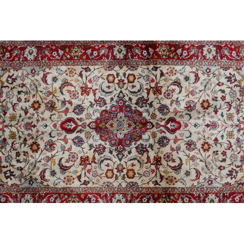 1086 - A Persian cream ground silk Tabriz rug with red borders, 62 x 122cm