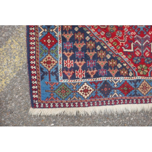 1089 - A south Persian Ghashgai red ground wool runner, decorated with a string of medallions, birds and fl... 