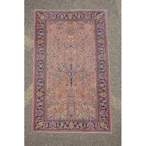 1090 - An antique Turkish pink ground wool rug with tree of life design, 82 x 130cm