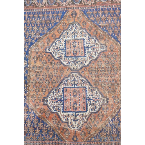 1094 - An antique Persian rust ground wool Hamadan rug with two cream ground geometric medallions, AF, 150 ... 