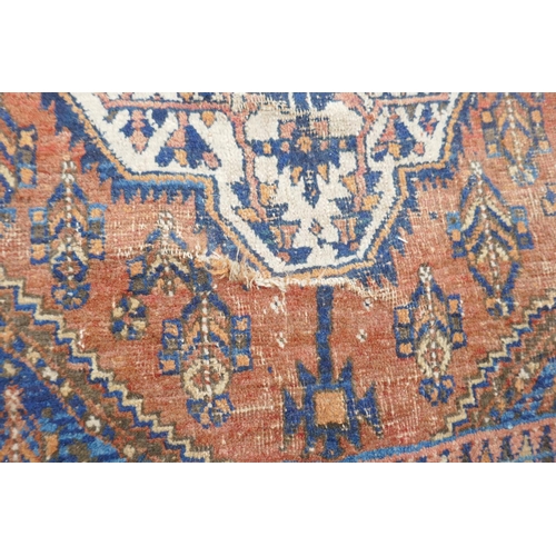 1094 - An antique Persian rust ground wool Hamadan rug with two cream ground geometric medallions, AF, 150 ... 