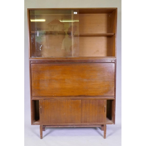 1096 - A mid century Beaver & Tapley Ltd multi width teak unit in two sections, the upper with sliding ... 