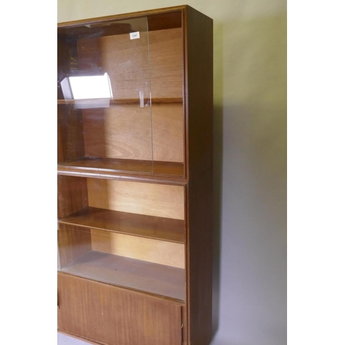 1097 - A mid century Beaver & Tapley Ltd multi width teak bookcase unit in two sections, with glass and... 