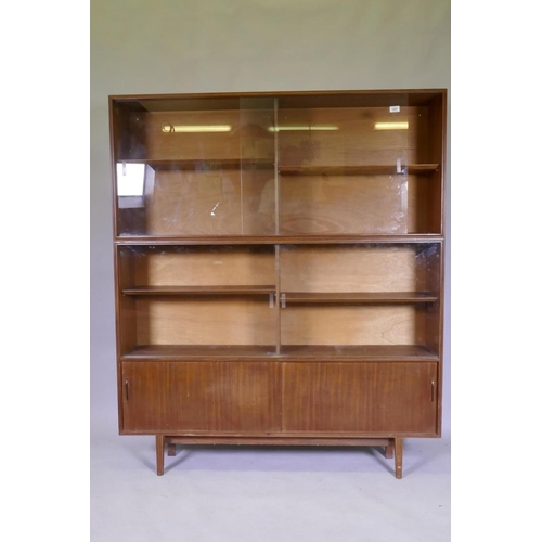 1097 - A mid century Beaver & Tapley Ltd multi width teak bookcase unit in two sections, with glass and... 