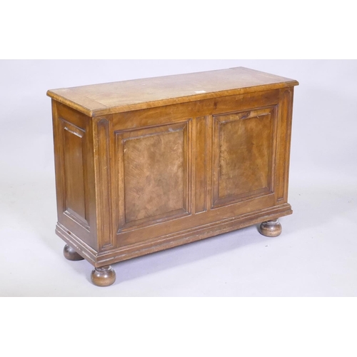 1106 - A figured mahogany blanket box/coffer, with lift up top and double fielded panel front, raised on tu... 