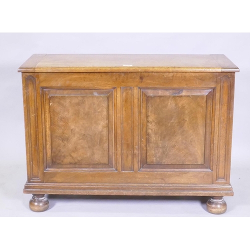 1106 - A figured mahogany blanket box/coffer, with lift up top and double fielded panel front, raised on tu... 