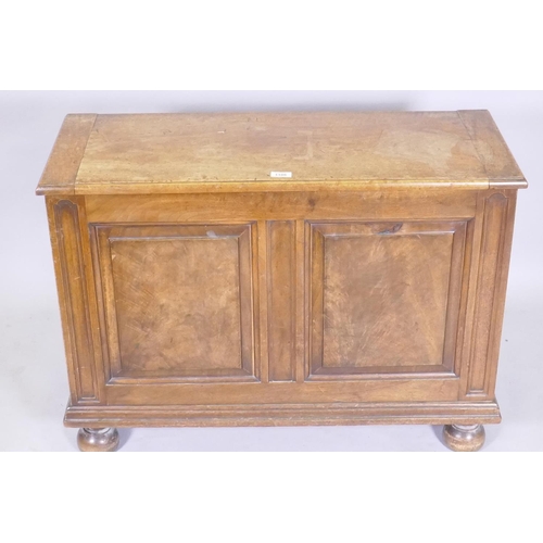 1106 - A figured mahogany blanket box/coffer, with lift up top and double fielded panel front, raised on tu... 