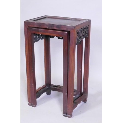 1119 - A nest of two Chinese hardwood tables, with carved and pierced dragon frieze, square supports and sh... 