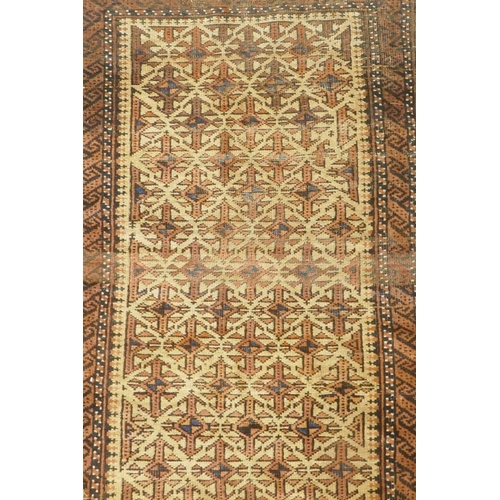 1121 - A gold ground Bokhara rug, and an Iranian rust and cream ground wool rug with an allover geometric d... 