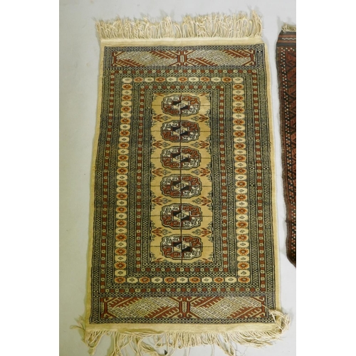 1121 - A gold ground Bokhara rug, and an Iranian rust and cream ground wool rug with an allover geometric d... 