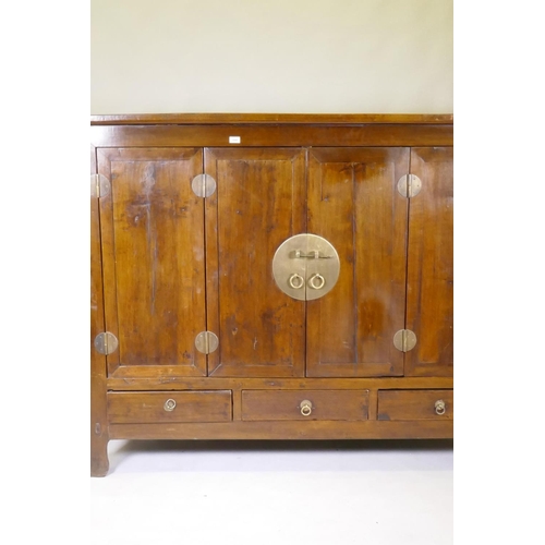 1136 - A Chinese hardwood cabinet with brass mounts and folding doors, raised on shaped supports, 186 x 64 ... 