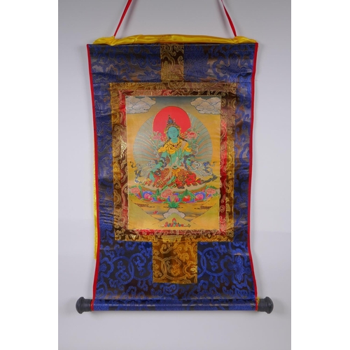 123 - A Tibetan printed Thangka with gilt details, on a silk scroll mount, 49 x 62cm