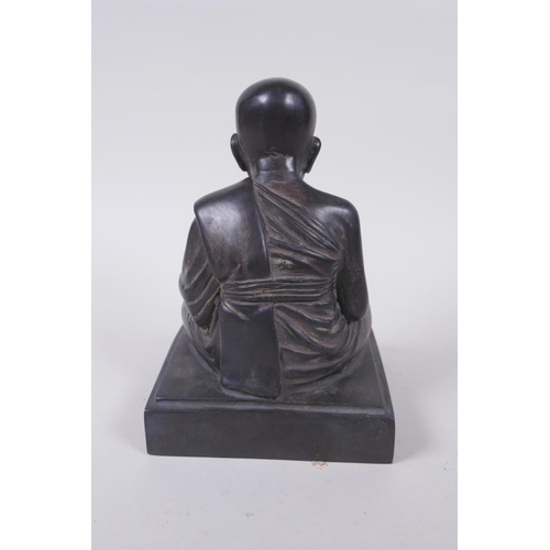 136 - A Tibetan filled bronze Buddha, inscription to front, 19cm high