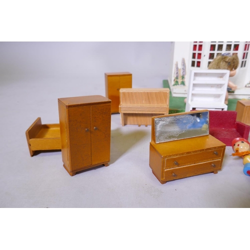 14 - A mid century doll's house with sliding metal front, illuminated and with furnishings, mounted on a ... 