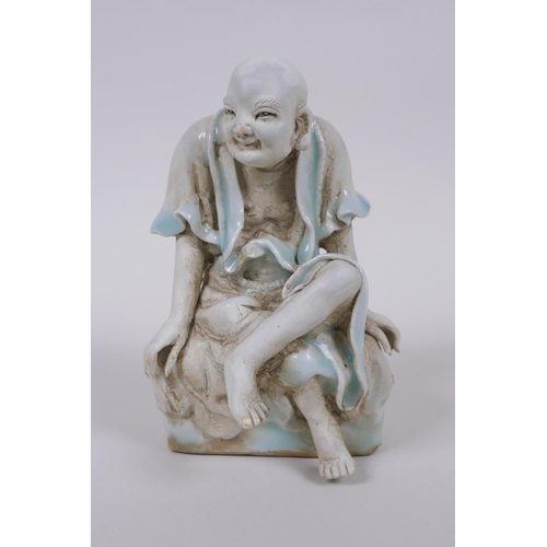 33 - A Chinese porcelain figure of Lo-han with celadon glazed features, 14cm high