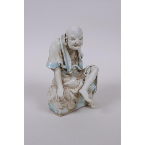 33 - A Chinese porcelain figure of Lo-han with celadon glazed features, 14cm high