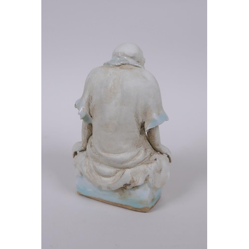 33 - A Chinese porcelain figure of Lo-han with celadon glazed features, 14cm high