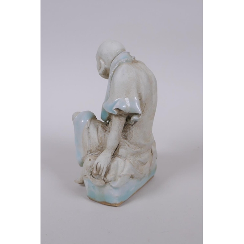 33 - A Chinese porcelain figure of Lo-han with celadon glazed features, 14cm high