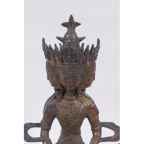 45 - A Tibetan bronze multi headed Buddha with remnants of gilt patina, 31cm high