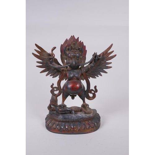 53 - A Tibetan bronze figure of Garruda with the remnants of gilt and copper patina, 28cm high