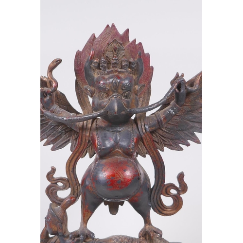 53 - A Tibetan bronze figure of Garruda with the remnants of gilt and copper patina, 28cm high