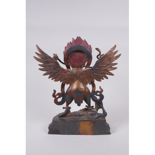 53 - A Tibetan bronze figure of Garruda with the remnants of gilt and copper patina, 28cm high