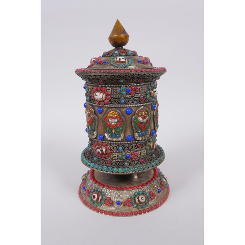 55 - A Tibetan white metal prayer wheel with painted details, set with agate eye beads, turquoise etc, 21... 