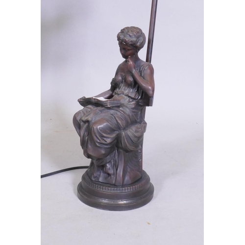 61 - A bronzed composition table lamp in the form of a seated young woman reading a book, 57cm high