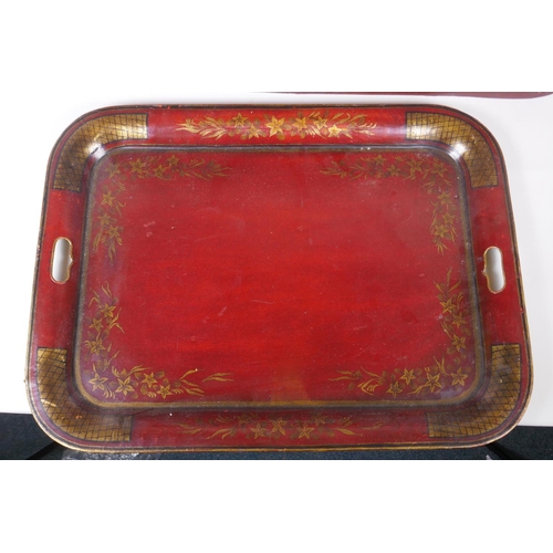 63 - A red ground Toleware tray with gilt decoration of birds and a fountain, and another smaller, larges... 