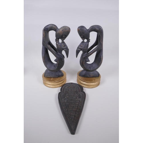 72 - A pair of African carved hardwood figure groups, and a Tibetan carved wood plaque, largest 28cm high