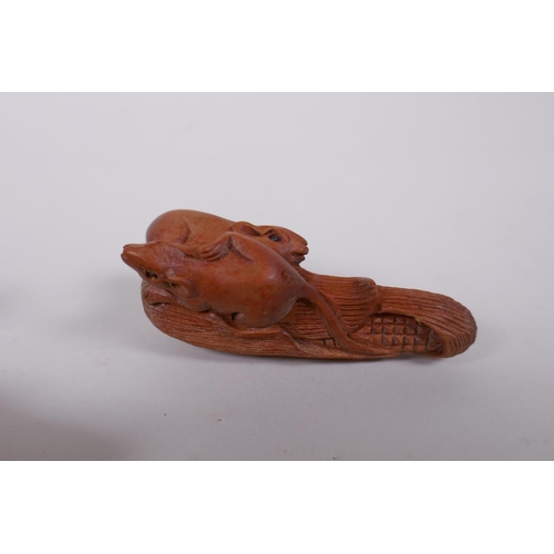 88 - Two Japanese carved boxwood netsuke in the form of rats on a corn husk and a warthog, together with ... 