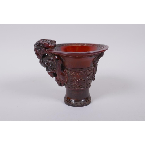 93 - A Chinese horn libation cup with climbing kylin decoration, character mark to base, 12cm high