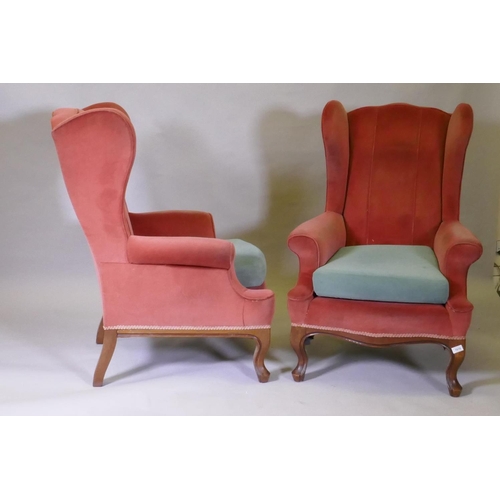 1094 - A pair of Georgian style wing back armchairs, with shaped backs