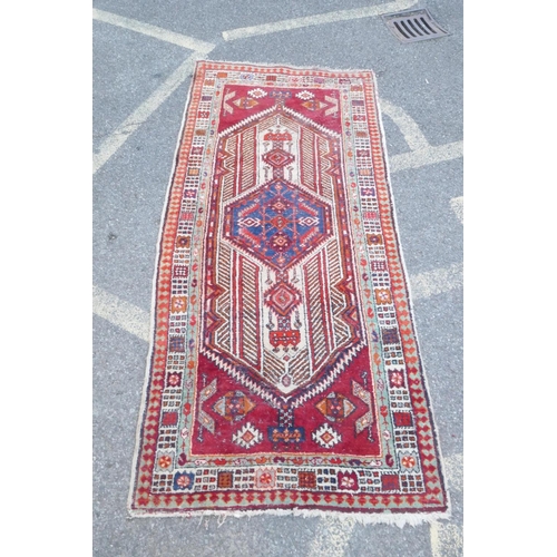 1086 - A red and blue ground flat weave runner, and a Persian red ground wool rug with a cream geometric de... 