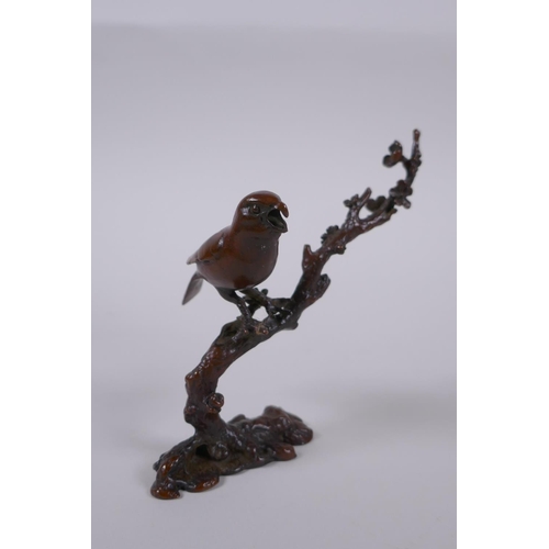 100 - A Japanese style bronze okimono of a bird perched on a branch, 10cm high