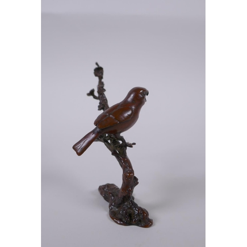 100 - A Japanese style bronze okimono of a bird perched on a branch, 10cm high