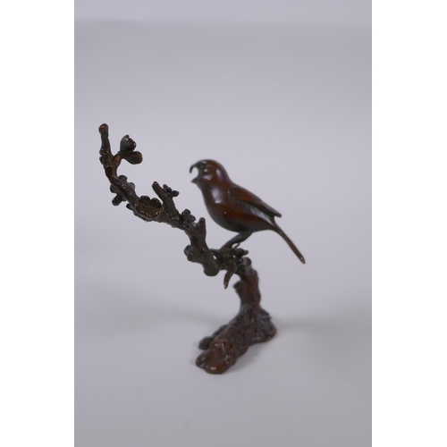 100 - A Japanese style bronze okimono of a bird perched on a branch, 10cm high