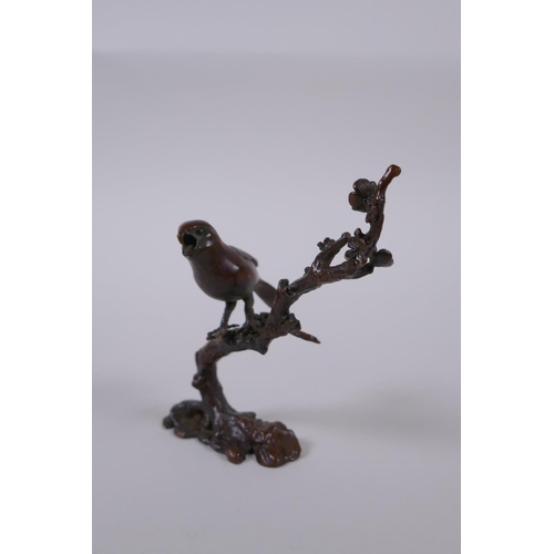 100 - A Japanese style bronze okimono of a bird perched on a branch, 10cm high