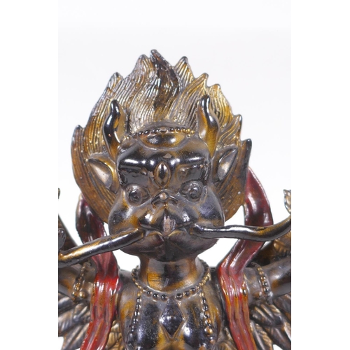 101 - A Tibetan lacquered and gilt bronze of Garuda standing on the back of a figure, 17cm high