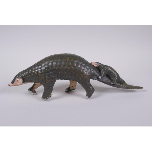 103 - A cold painted filled bronze figure of a pangolin with a pup riding on its back, 32cm long